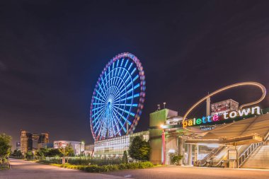 Tokyo, Japonya - 24 Ağustos 2018: Odaiba, yaz gecesi gökyüzünde şehir merkezinden Daikanransha adı verilen Palette Town dönme dolabını aydınlattı. Yolcular Tokyo Kulesi 'ni, ikiz güverte Gökkuşağı Köprüsü' nü görebilirler.