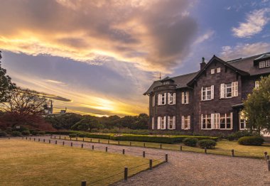 Tokyo, Japonya - Aralık 04: 2019: Tokyo Büyükşehir Parkı 'nda günbatımı Kyufurukawa' nın Red Maple Momiji 'deki eski batı tarzı malikanesi sonbaharda ayrılıyor.
