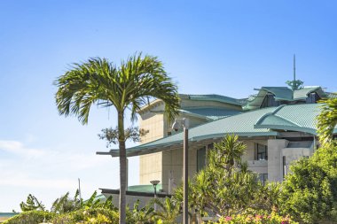 Ginowan City tropikal plaj yakınında palmiye ağaçları ile dekore Okinawa Kongre Merkezi Binası