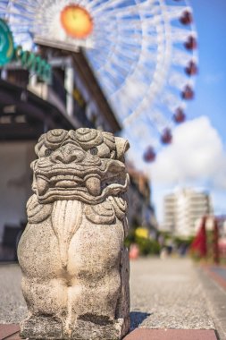 Okinawan Shisa aslan ve Chatan City American Village mahallede bulunan Mihama Carnival Park Dönme dolap Okinawa Sunset Beach yakınında palmiye ağaçları ile dekore.