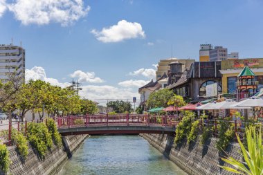 American Village, Japonya - 17 Eylül 2018: Chatan City nehri ve kırmızı çelik köprü American Village'da
