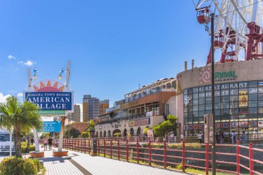American Village, Japonya - 17 Eylül 2018: Chatan City kırmızı çelik köprü ve Mihama Carnival Park Dönme dolap American Village