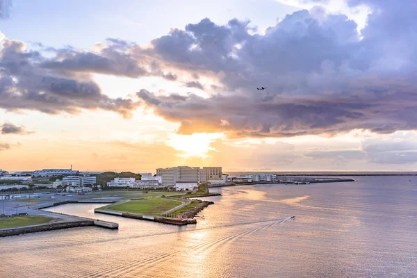 Repülőgép repül át a naplementét tenger Sumiyoshi kerület Naha City Okinawa szigeten — Stock Fotó