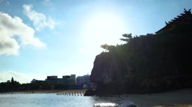 Okinawa Prefecture, Japonya'da Naha plaj ve okyanus bakan bir uçurumun tepesinde Shinto Tapınağı Naminoue gündoğumu manzara Pan video.