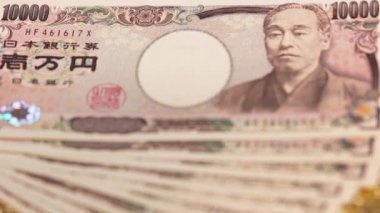 Yakın çekim odak videosu altın bir kağıt üzerinde 100.000 yen nakit.
