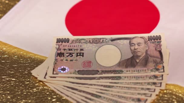 Slide video van 100.000 yen in contanten op een nationale vlag en gouden papier. — Stockvideo