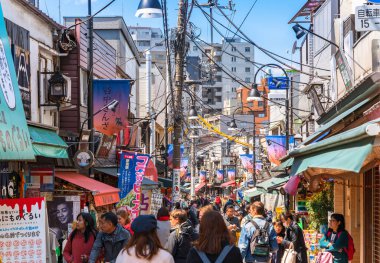 Tokyo, Japonya - 31 Mart 2020: Tokyo 'da Yanaka Ginza' nın eski moda geleneksel mağazaları ve maskot kedisi Sen adlı maskotuyla ünlü retro alışveriş caddesinde yürüyen turist kalabalığı.