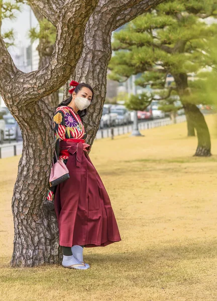 Japońska Kobieta Ubrana Hakama Kimono Nosząca Maskę Twarzy Opartą Pień — Zdjęcie stockowe