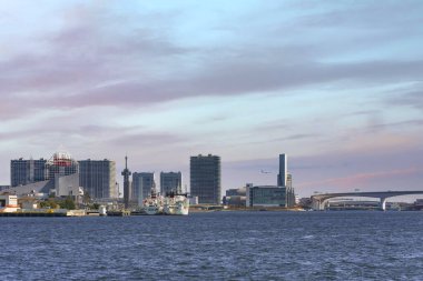 Tokyo Körfezi 'ndeki Harumi Yolcu Terminali' nde gün batımında Ariake Adası 'nın önünde demirlemiş tekneler..
