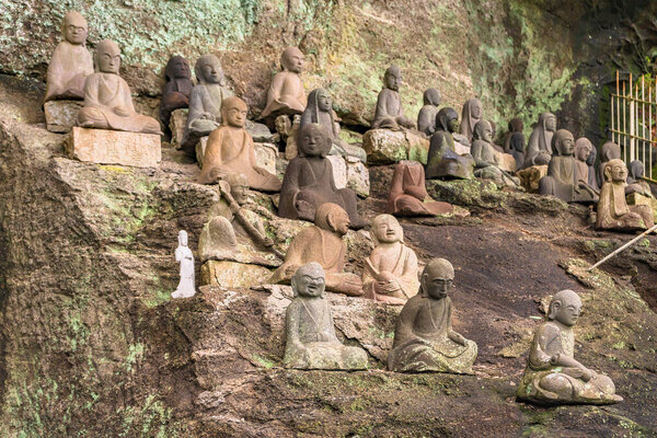 chiba, japan - july 18 2020: Statues of buddhist deities and monks surrounding the sculpture of Saigoku Kannon bodhisattva created in 18th century by Jingoro Eirei Ono in the Mount Nokogiri.