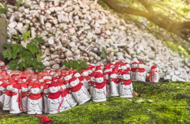 Binlerce Budist cehennem koruyucu tanrısı Jizo Bosatsu, Nokogiri Dağı 'ndaki Nihonji tapınağının yosunlarına ölen çocuklar için kep ve kırmızı önlük takıyor..