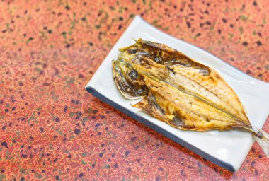 Çiçek kenevir yaprağı gümüş desenli masa örtüsünde geleneksel Japon ızgara balığı..