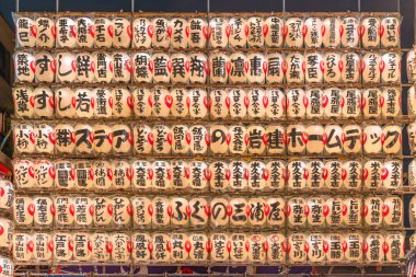 asakusa, Japonya - Kasım 08 2019: Ootori Tori-no-Ichi Tapınağı 'nın el yazısıyla süslenmiş Japon kağıt fenerlerinden oluşan dev bir duvar manzarası.
