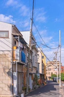 Sumida, Kanegafuchi 'nin şehir merkezindeki kırsal bölgede paslı çarşaflardan yapılmış tipik Japon evleri ve balkonda asılı ahşap tahtalar var..