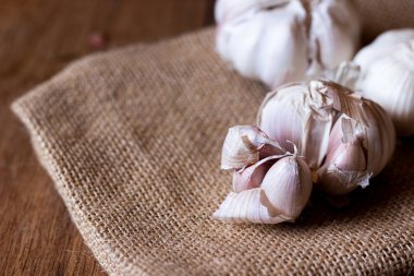 çuval bezi ve ahşap masa üzerinde sarımsak karanfil yakın