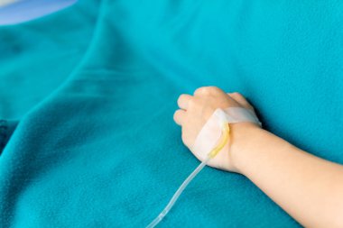 Hastanın eli iğneyle delinmiş. Tuzlu su hortumu takmak için scotch bant ile elin arkasına bağlı