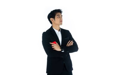 Yakışıklı genç işadamı Asya beyaz siyah saçlı siyah bir takım elbise giymek, bir gülümseme ve ayakta akıllı pozlar olmak. Akıllı telefonu tutun ve kullanın. Beyaz arka planda.