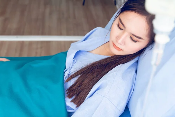 Asiática jóvenes pacientes con camisas azules acostados en la cama con una cara brillante tienen mejores síntomas mientras esperan a que el médico revise —  Fotos de Stock