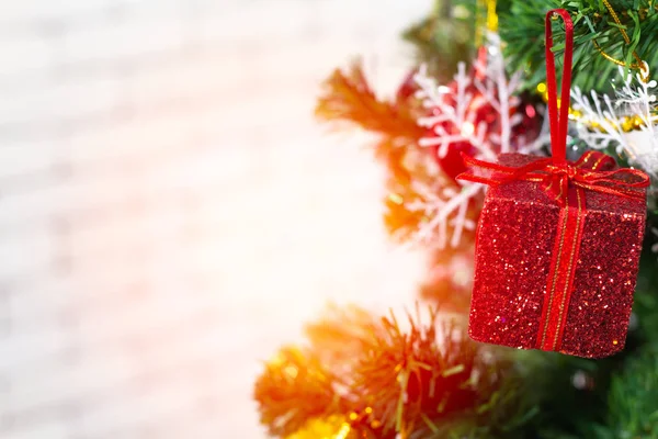 Una caja de regalo roja colgada de un árbol de Navidad. Ideas para dar la bienvenida a la —  Fotos de Stock