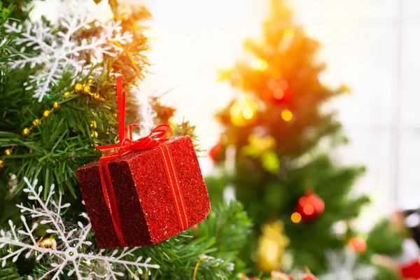Una caja de regalo roja colgada de un árbol de Navidad. Ideas para dar la bienvenida a la —  Fotos de Stock