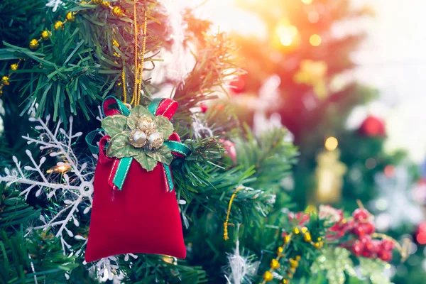 Una pequeña bolsa roja colgando en el árbol de Navidad Ideas para dar la bienvenida a la u —  Fotos de Stock