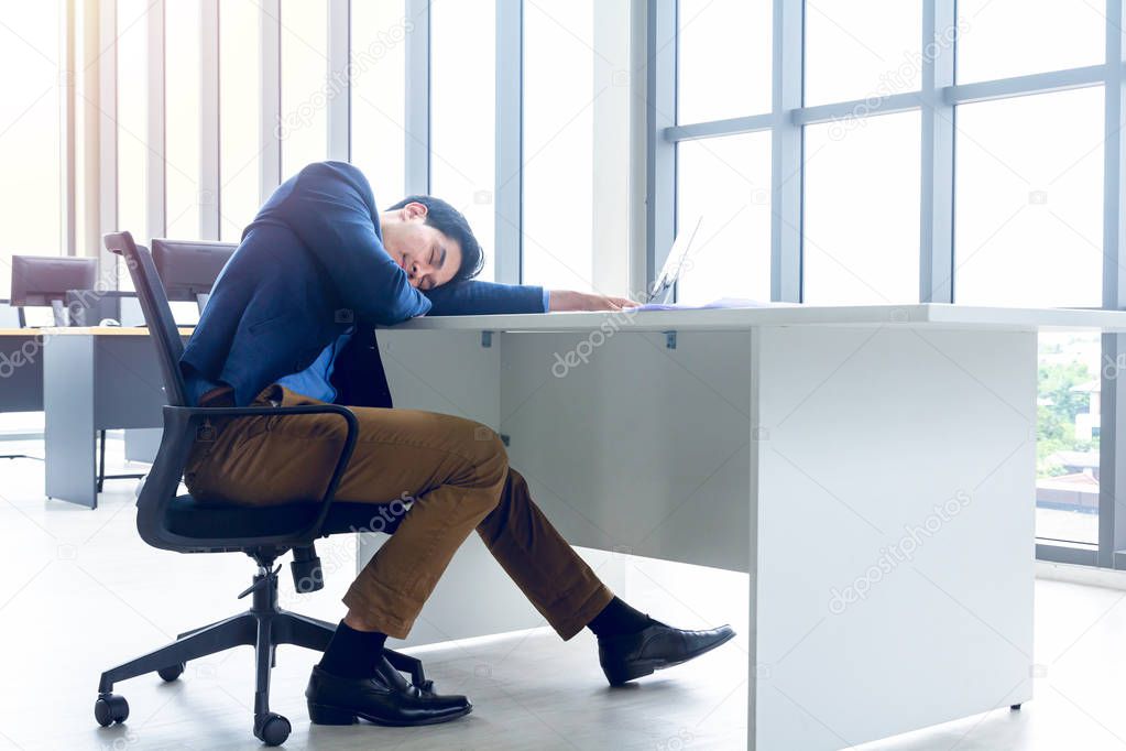 A young businessman sitting in a modern office. He has a feel sl