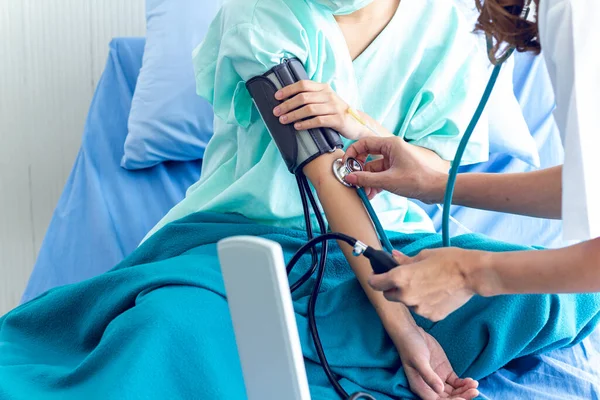 Female doctors medical examination pressure measuring of female patients on hospital bed.