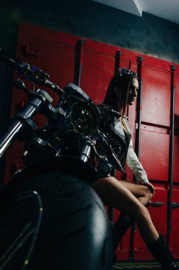 Bir bisiklet yakınındaki yüksek topuklar üzerinde deri sıkı uygun giysili güzel kızı