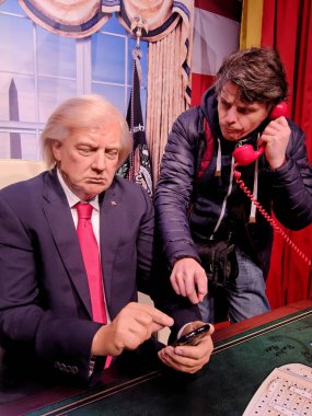 Blackpool, 14 Ocak: Madame Tussauds, İngiltere'de 2018. Başkan Donald Trump bir cep telefonu ve kırmızı telefonda konuşurken fuar ziyaretçilerine işaret eden balmumu rakam.