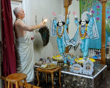 Paris, August 27: The main altar in the Hare Krishna temple called 'ISKCON Radha-Parisisvara', France 2018. The priest offers candles made of refined butter 'ghee'