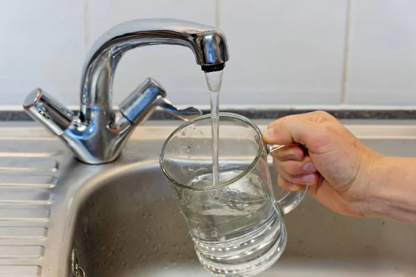 Ludzką Ręką Trzymając Szkła Odlewania Świeży Napój Woda Bateria Kuchenna — Zdjęcie stockowe