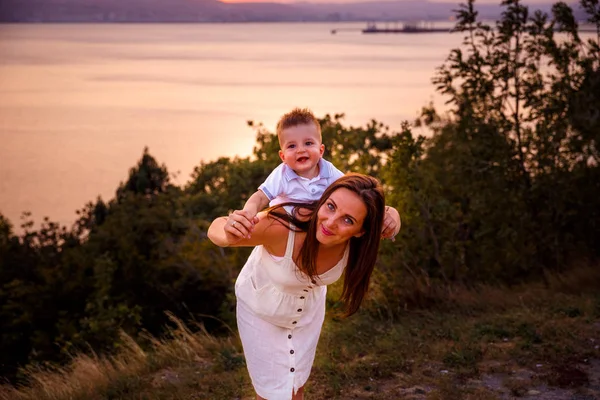 mother and son at sunset by the sea,family,