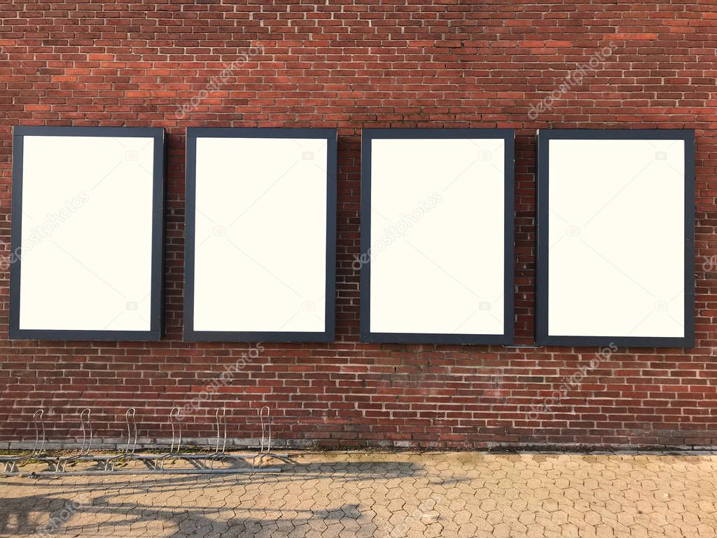 Four blank billboards on the brick wall