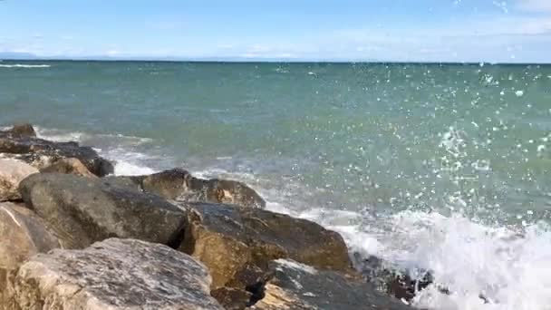 ホワイト海の泡と 大きな海の波しぶきは晴れた日で濡れた石の海岸に削除します 夏の青空の下で新鮮なアクアマリン色の海水パワー — ストック動画