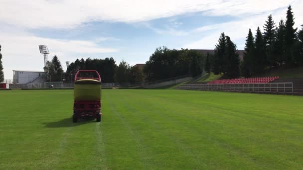 红黄割草车在足球场上割绿草 赛前割草机 — 图库视频影像