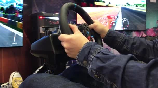 捷克布尔诺 10时 游戏玩家使用方向盘模拟器玩电子游戏机 男人和男孩玩赛车与游戏车轮 游戏玩家在游戏站上与汽车模拟器比赛 — 图库视频影像