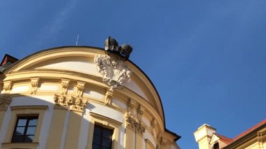 Çatı tavan cephesinde tarihsel Austerlitz Kalesi, South Moravia, Çek Cumhuriyeti. Slavkov Sarayı, mavi gökyüzü üzerinde korniş yan yatan. Güvercinler Slavkov u Brna binada Barok çıkıntının üzerinden dışarı dönmeye başladı. İki el silah sesi.