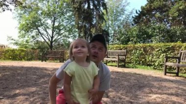 Baba ve küçük kız yaz Park gökyüzüne bak. Küçük çocuk noktası yukarı doğru. Meraklı mutlu bebek kız ve baktılar adam çeneni izleyin. Yetişkin ve yürümeye başlayan çocuk birlikte yüksek uçakta sonra günde bkz: