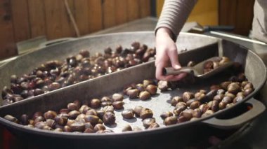 Tatlı kestaneler, büyük tava üzerinde geleneksel Fuar süresince kadın eli onları spatula tarafından kıpırdanırken komisyon ve onları yemek. Avrupa sokak lokanta kış piyasalarda. Mevsimlik incelik, tatil, geleneksel way pişirme