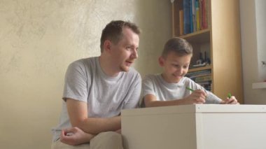 Baba ve oğul - çocuk odasında masada tavsiye veren üst. Adam çocuğu evde ev ödevlerinde yardım. Varoluş yetişkin 's kontrol altında öğrenme. Genç babamla konuşmak ve onun dikte için yazmak. Ana sayfa eğitim. İki el silah sesi