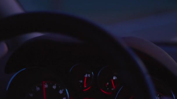 車のダッシュ ボードのクローズ アップは スピードとコントロール パネル ゲージ 燃料消費量ステアリング ホイールと暗闇の中で車の運転の前に信号の手 シッター ビュー内部のゲージに焦点を当てる — ストック動画