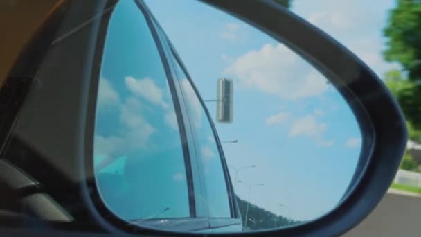 デイライトから暗いトンネルまで走行する車の右側のリアビューミラー 雲やランプポストを反射する自動車ミラー 高速道路の夕暮れ時のトンネルライト 車内のシッターまたは乗客の視点 休暇の概念 — ストック動画