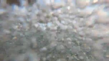 Mavi bulutlu gökyüzü altında deniz köpüğü yıkama-aşağı sahil ile yaklaşan deniz dalgası, zemin sualtı sıçraması. gelen dalgaların ollapse taş kıyı yıkama. Kara deniz dalgaları kayalara çarpıyor. Dalgaların üzerinde kıvrılma ve dalganın geri taslağı