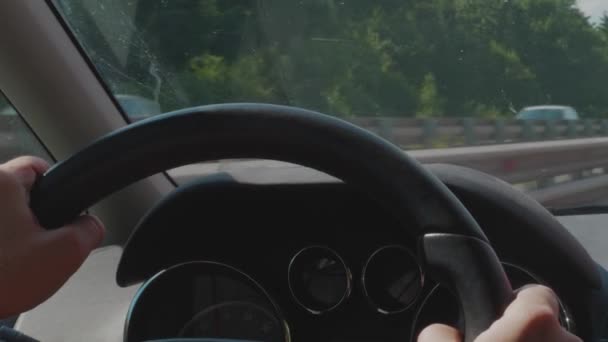 高速道路上のトラフィックで運転する車 ドライバーの手でハンドル 自動車ダッシュボード モバイルナビゲーション 汚れたフロントガラス フロント画面の交通会議のぼやけた輪郭 ドライブ中にホイール コントロールパネルに焦点を当てます ハンドヘルド ピーク時 — ストック動画