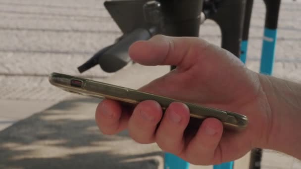 Άνθρωπος Χέρι Χρησιμοποιώντας Smartphone Για Ανέπαφες Πληρωμή Των Ηλεκτρικών Σκούτερ — Αρχείο Βίντεο