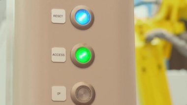Mavi ve yeşil ışık yakma düğmeleri çalışıyor üretim üretim sürecini gösteriyor, boş düğme kapalı, arka planda lazer otomasyon makinesi var. Üretim üzerinde çalışan makine döngüsü düğmelerine bas. Işıklı bisiklet sinyalleri