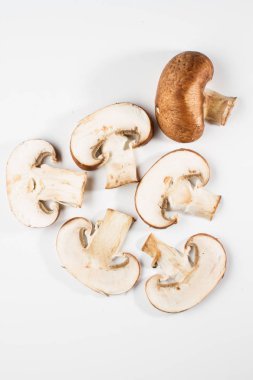 Bir yığın beyaz arka plan üzerinde izole kahverengi champignon bütün ve dilimlenmiş mantar