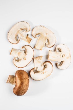 Bir yığın beyaz arka plan üzerinde izole kahverengi champignon bütün ve dilimlenmiş mantar