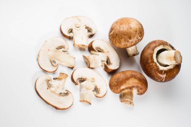 Bir yığın beyaz arka plan üzerinde izole kahverengi champignon bütün ve dilimlenmiş mantar