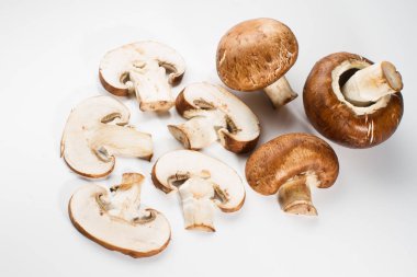 Bir yığın beyaz arka plan üzerinde izole kahverengi champignon bütün ve dilimlenmiş mantar